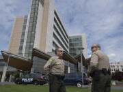 Undersheriff Mike Cooke of the Clark County Sheriff's Office, left, talks with Chief Criminal Deputy John Chapman as they respond to the scene of a shooting at PeaceHealth Southwest Medical Center on Thursday morning.