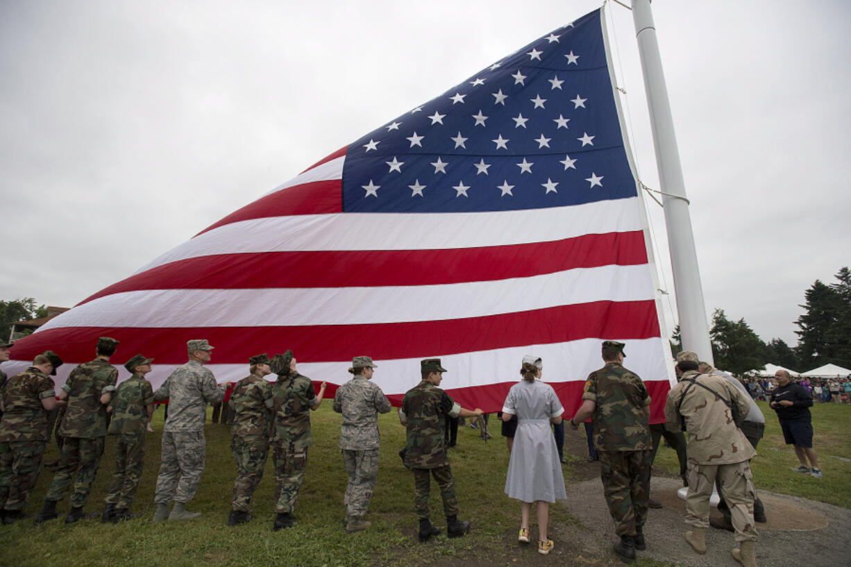 Participants in the annual Memorial Day Observance help with the dedication of the newly reconstructed Garrison flagstaff during the ceremony at Fort Vancouver National Historic Site on Monday morning.