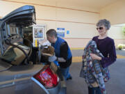 Froilan Valencia of Goodwill, left, assists Vancouver resident Barbara Duncan as she drops off donations at the Fisher’s Landing Goodwill on Wednesday afternoon. This is the busiest Goodwill in Clark County.