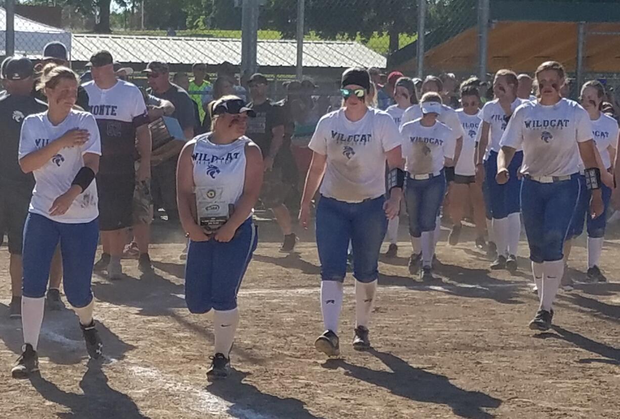 La Center pitcher Abby England holds the second place trophy as her teammates follow her after their loss to Montesano in the 1A state title softball game (Paul Valencia/The Columbian)