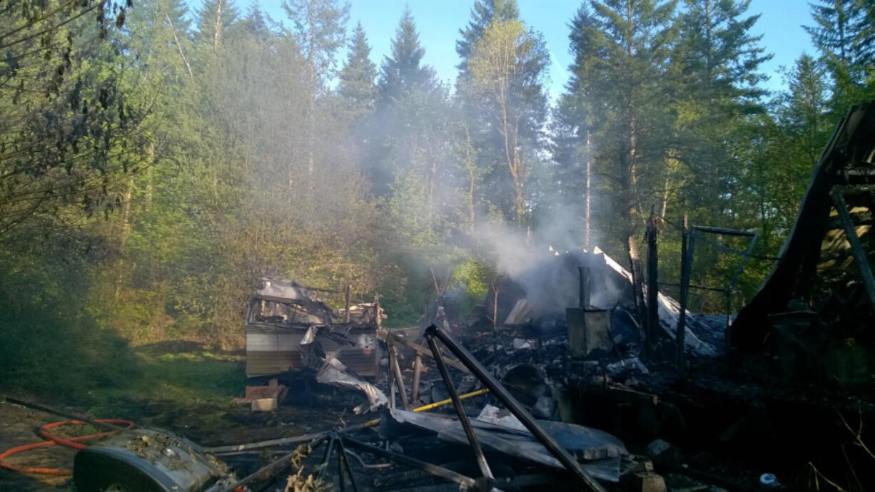 Smoke rises from the ruin left over after a fire in a travel trailer and manufactured home Tuesday afternoon. Firefighters responded to a similar fire, in a motor home, on the same property Monday.