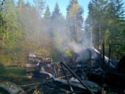 Smoke rises from the ruin left over after a fire in a travel trailer and manufactured home Tuesday afternoon. Firefighters responded to a similar fire, in a motor home, on the same property Monday.