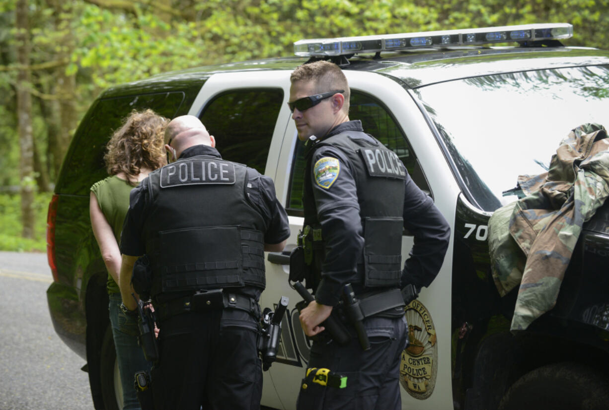 La Center Police Officer Andy Marvitz, right, covers for Sergeant Robert Scott during a welfare check after Marvitz had to stall while waiting for backup. The La Center Police Department is at minimum staffing levels to provide 24-hour service, and with an uncertain financial future in the city, the department might not be able to bring in additional help.