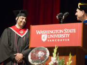 Julian Rivas, left, received the Chancellor&#039;s Award for Student Achievement Saturday at the Washington State University Vancouver graduation at Sunlight Supply Amphitheater in Ridgefield. At right is Chancellor Mel Netzhammer. (Randy L.