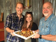 Caleb and Kayla Sturtevant from Botany Bay Farms and Russell Brent of Mill Creek Pub with a close-up of the roasted chicken dinner for two. The restaurant will be serving locally raised farm chickens from Botany Bay Farms and produce from Red Truck Farm.