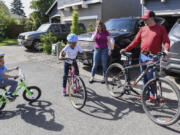 Photos by Ariane Kunze/The Columbian
Siblings Tray, 4, left, and Lakiyah Granning, 7, ride their bikes while Kimberly and Eric Granning watch outside their home in Vancouver.