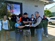 Spyder Ryders Treasurer Joyce LaFlam, left, and President William Pyne, right, present Jeff Talbott of Kleen Street Recovery Cafe with a check for the cafe’s work with the homeless.