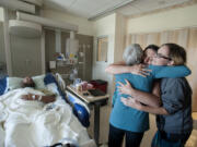 Scott Jensen of Amboy rests in his hospital bed in July as his mom, Therese Jensen, with back to camera, thanks the women who helped save his life, Hiedi Poulson of Brush Prairie, from left, and Kim Detter of Battle Ground, far right, at PeaceHealth Southwest Medical Center. The Columbian's Amanda Cowan received a runner-up certificate from the Society of Professional Journalists for the photo.