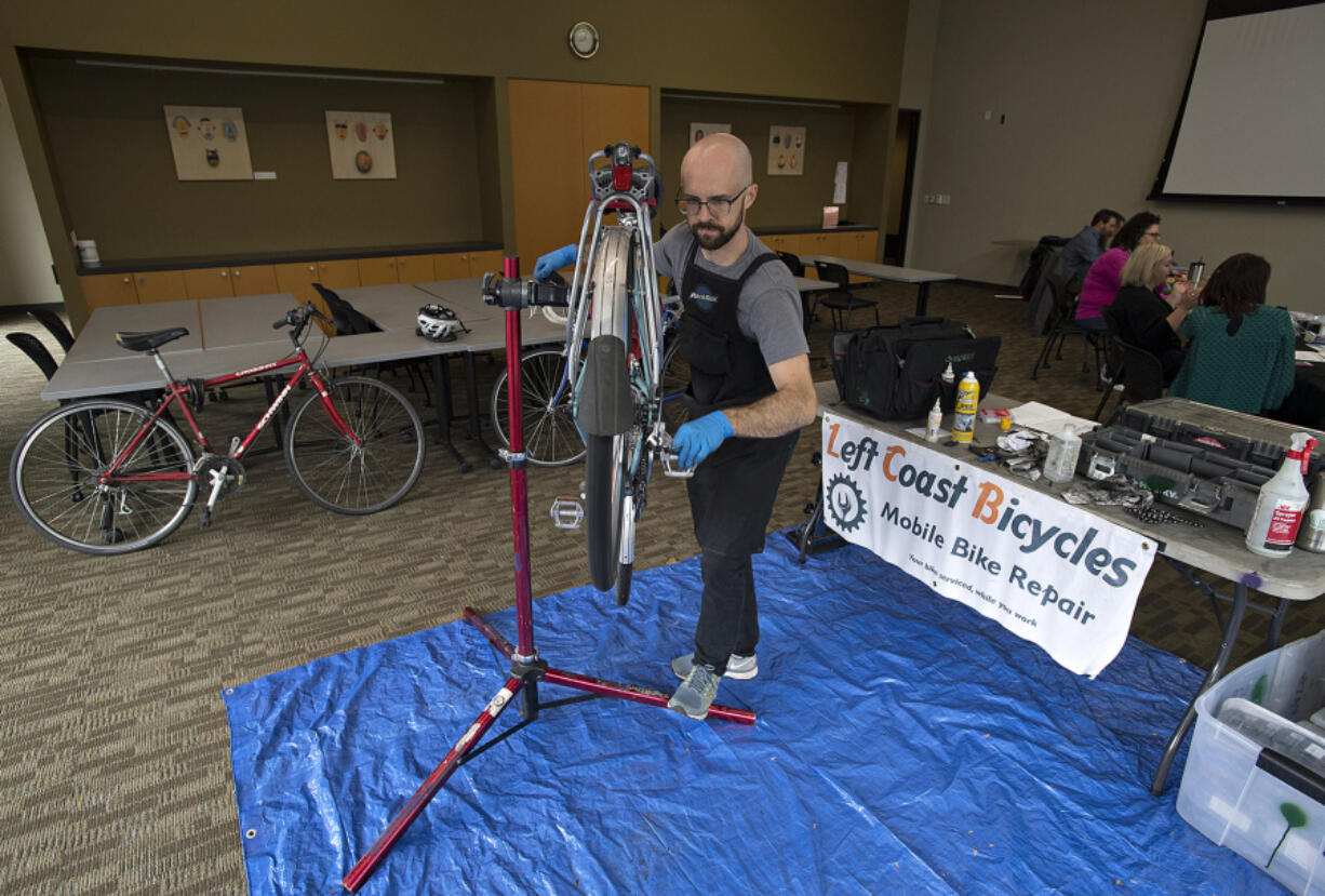 Aaron Michalson, owner of Left Coast Bicycles, repairs a bicycle during mobile bike clinic at Vancouver City Hall on Thursday. The clinic was aimed at getting downtown cyclists’s rides tuned up and ready for the biking season.