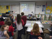 Cape Horn-Skye Elementary School second-graders line up to ask questions to their classmate, Zylus Italiano, 7, top, as he is broadcast on the screen from Nepal during his weekly video chat while he&#039;s traveling around with world with his parents.