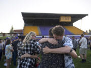 Columbia River High School senior Ethan Adams, 18, in tan and black shirt, and junior Ryan Connop, 17, right, lean on each other for support as they pause to honor the memory of their friend, Hunter Pearson, on the school’s football field Monday evening, May 29, 2017. Hunter Pearson, a senior and football player, presumably drowned Saturday in a swimming accident at Lacamas Lake. Students wore Hawaiian shirts to honor his sense of style.