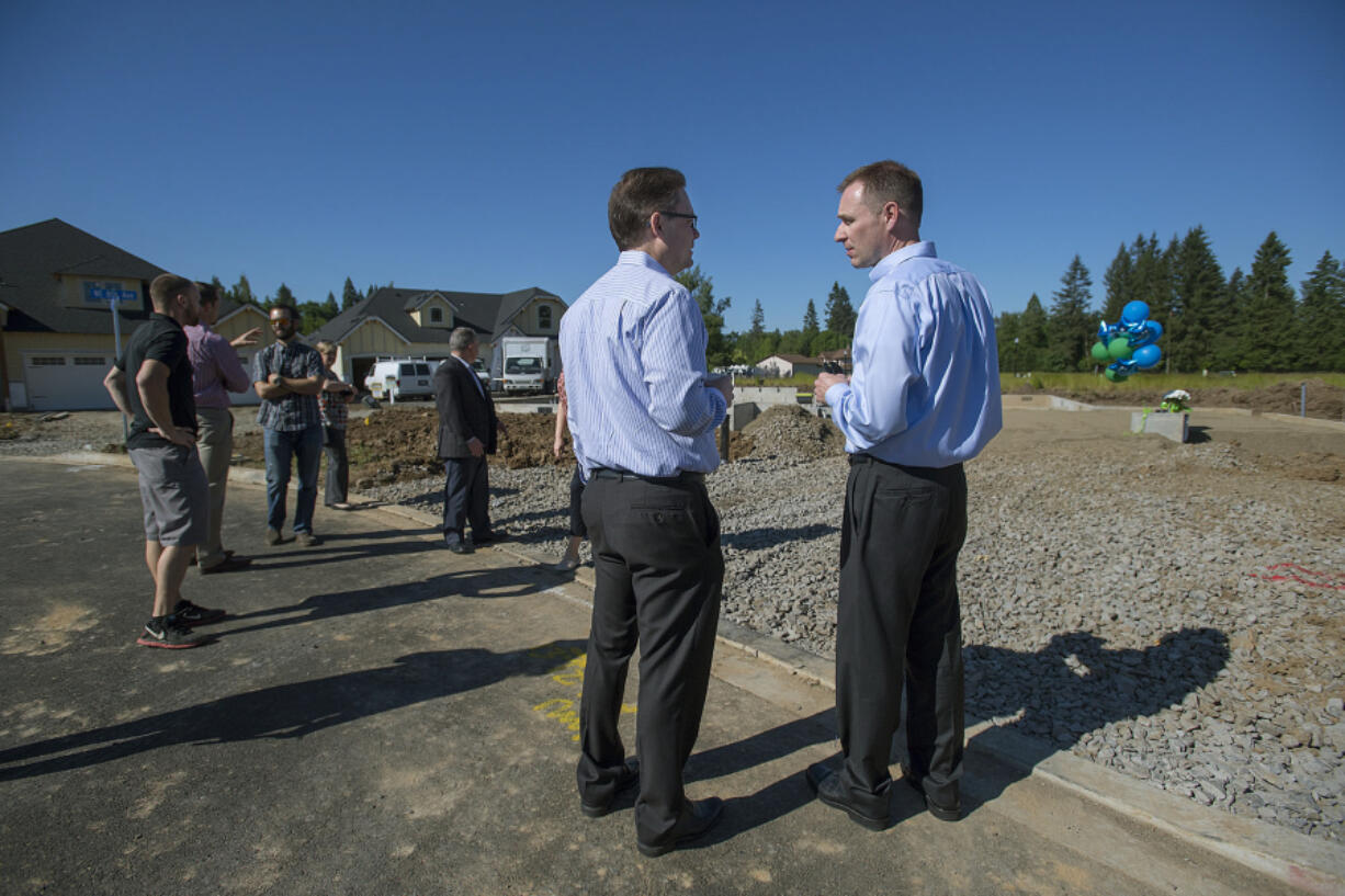 Kevin Wann, center, owner of Pacific Lifestyle Homes, chats with Matthew Butte, development director of Children’s Center, while celebrating the Giving House in northeast Battle Ground on Tuesday morning. Children’s Center is one of the nonprofits benefiting from the sale of the home. “To get the goodwill going, it’s a community effort,” Wann said.