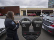 Parking enforcement officer Jessica Keenan tickets two vehicles, both for an expired meter, in downtown Vancouver on Thursday morning. Officers are writing more tickets than in the past five years.