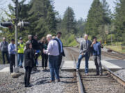 Gov. Jay Inslee, second from right, is escorted by BNSF Railway spokesman Gus Melonas as they gather with others Tuesday afternoon at a Skamania County rail crossing to learn more about rail safety.