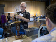 Volunteer Dave Meigs works on a lamp at the Repair Café Thursday at the Vancouver Community Library. Repair Café brings together volunteer fixers who repair items for free.