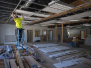 Peter Slauson of EZ Systems installs ceiling tiles in the Salvation Army’s new building in Washougal. The building came from the Bellevue Salvation Army and was trucked to the Washougal site.