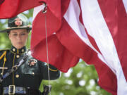 Elizabeth Kienle, a corrections deputy and member of the Multnomah County Honor Guard, helps raise a flag during a memorial ceremony honoring law enforcement officers who have died in the line of duty Thursday outside of the Clark County Public Service Center.