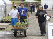 Steve Dipaola for The Columbian
Eleven-year-old Randall Conner, from left, 13-year-old Greg Conner and their mother, Terry Conner, leave the Master Gardener Foundation of Clark County’s annual plant sale Sunday. Many plant sale guests brought, or were shopping for, mom.