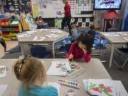 Kindergartner Grace Huynh, 5, facing in pink, joins classmates as they work on a painting during class at Prune Hill Elementary School on April 13.