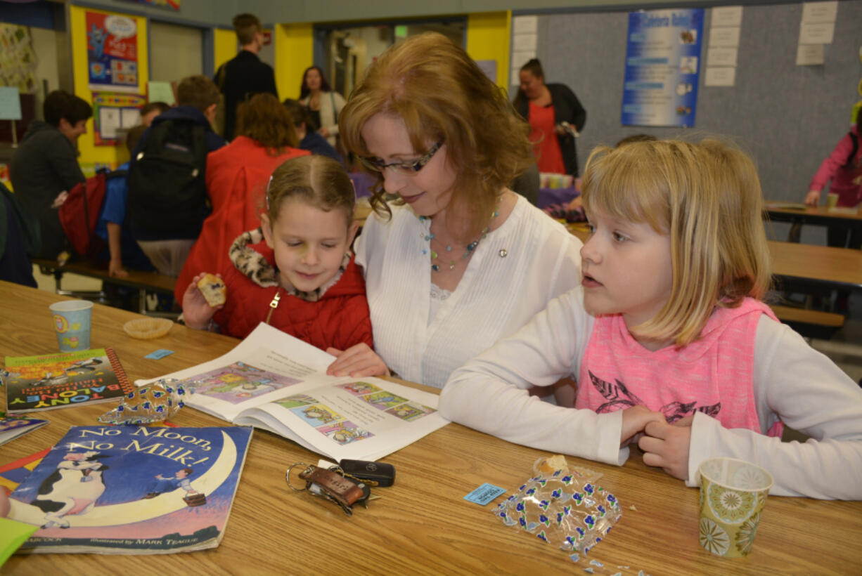 Washougal: Emerson Fletcher, from left, Kalle Fletcher and Elliot Fletcher during Gause Elementary School's sixth annual Moms and Muffins event, where adults come to school to read to children and enjoy some treats.