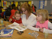 Washougal: Emerson Fletcher, from left, Kalle Fletcher and Elliot Fletcher during Gause Elementary School's sixth annual Moms and Muffins event, where adults come to school to read to children and enjoy some treats.