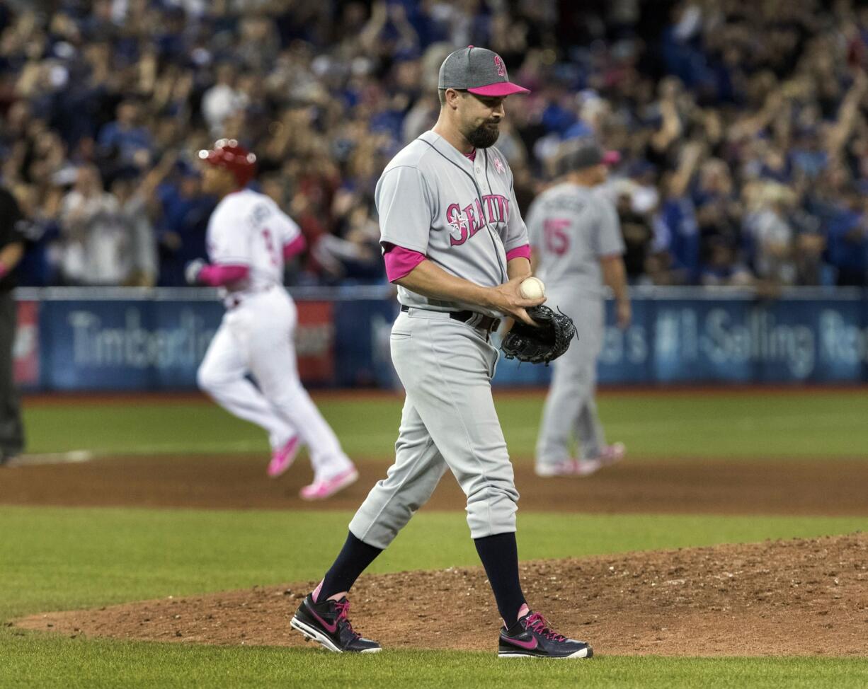 Seattle Mariners pitcher Nick Vincent walks off the mound after giving up a three-run home run to Toronto Blue Jays' Jose Bautista in the seventh inning of a baseball game in Toronto on Saturday May 13, 2017.