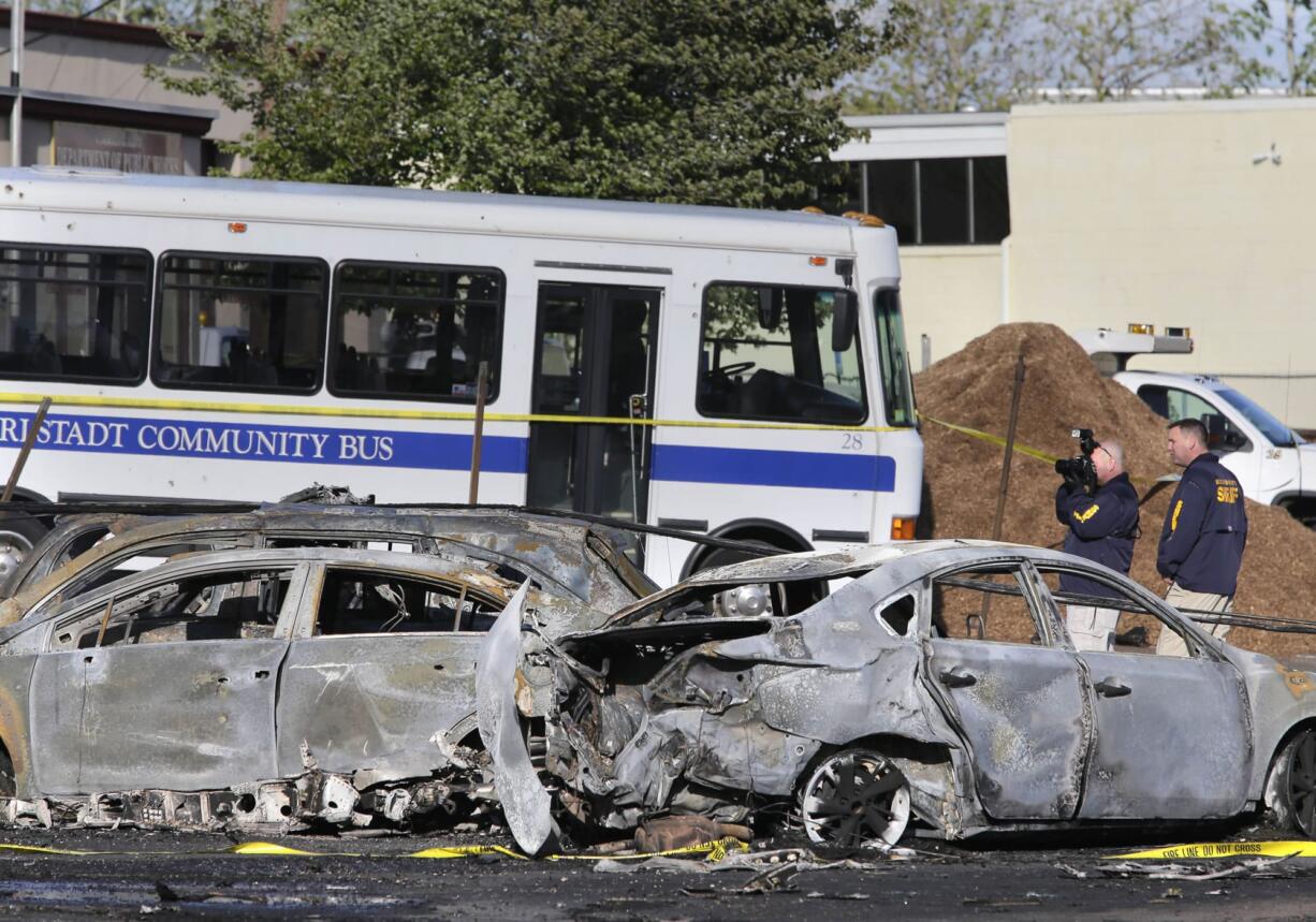 Police officers take pictures near the site of a deadly small plane crash near Teterboro Airport in Carlstadt, N.J., just west of New York City, Monday, May 15, 2017. Police said a Learjet 35 crashed into a building near the airport sparking a fire that sent thick, black smoke spewing into the air.