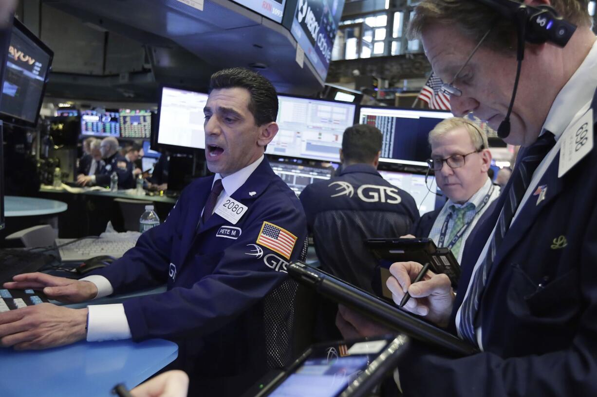 Specialist Peter Mazza, left, works with traders on the floor of the New York Stock Exchange, Wednesday, May 17, 2017. Stocks are opening lower on Wall Street as banks and industrial companies fall.