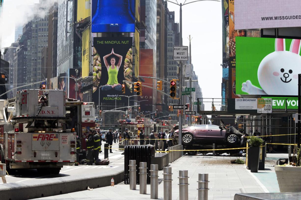 A car rests on a security barrier in New York's Times Square after driving through a crowd of pedestrians, injuring at least a dozen people, Thursday, May 18, 2017.