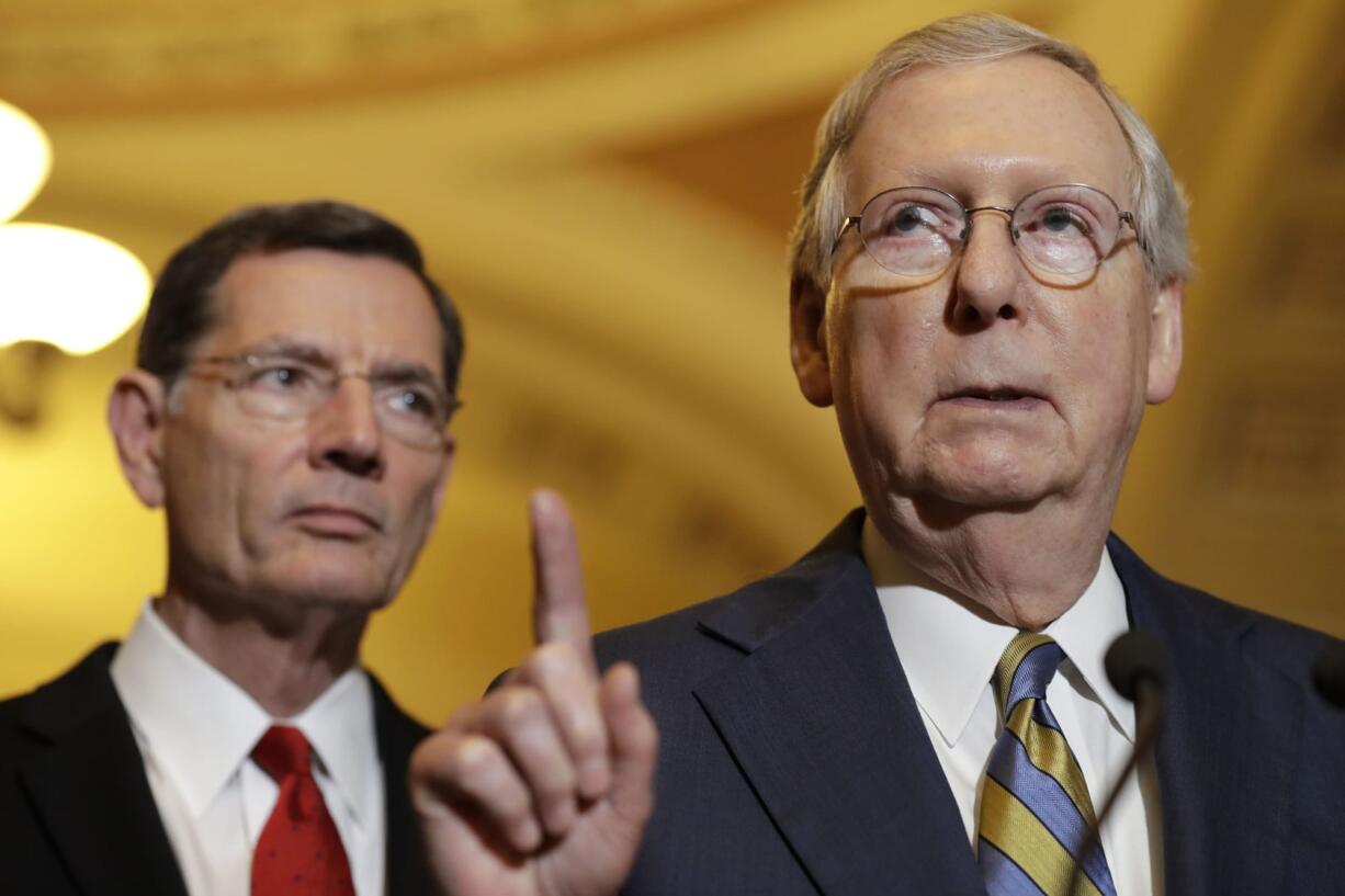 Senate Majority Leader Mitch McConnell of Ky., right, accompanied by Sen. John Barrasso, R-Wyo., meets with reporters on Capitol Hill in Washington, Tuesday, May 23, 2017, following after a Republican policy luncheon.