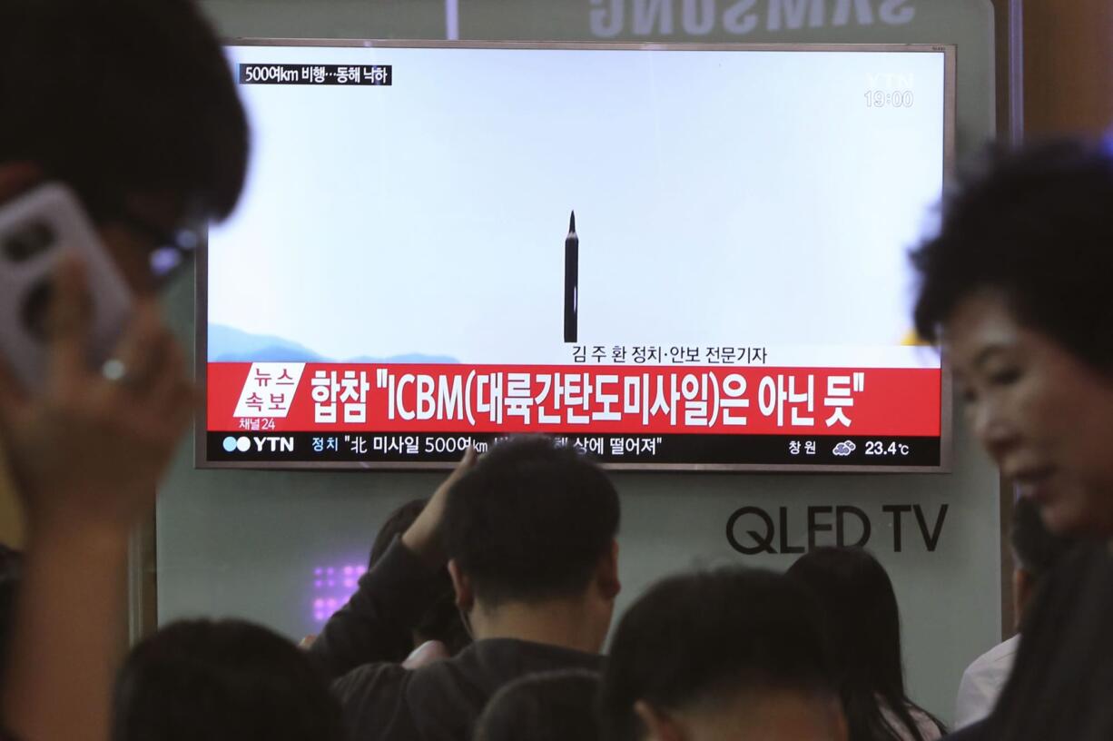 FILE - In this May 21, 2107 file photo people watch a TV news program showing a file image of a missile launch conducted by North Korea, at the Seoul Railway Station in Seoul, South Korea. With North Korea’s nuclear missile threat in mind, the Pentagon is planning a missile defense test next week that for the first time will target an intercontinental-range missile.