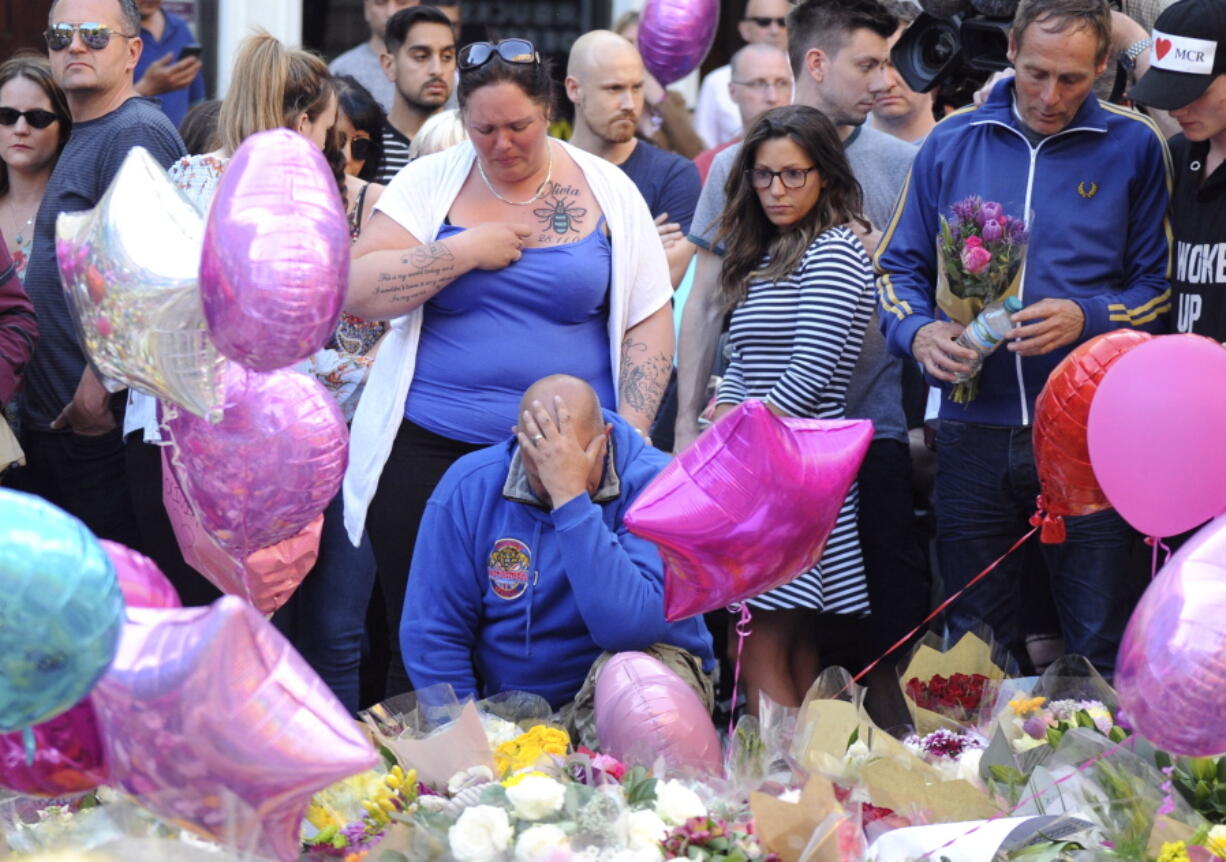 Olivia Campbell’s mother, Charlotte Campbell, center, and stepfather Paul Hodgson, foreground, pay tribute to the victims of the explosion Thursday outside Manchester Arena, at St. Ann’s Square after leading a bikers convoy from their home town of Bury in central Manchester, England.