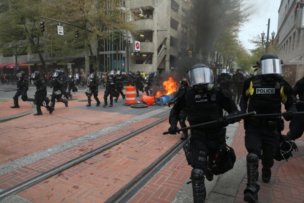 Police disperse people participating Monday in a May Day rally in downtown Portland. Police in Portland said the permit obtained for the May Day rally and march there was canceled as some marchers began throwing projectiles at officers.