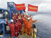 Workers celebrate May 16, 2017, the successful trial extraction of natural gas from combustible ice trapped under the seafloor on a drilling platform on the South China Sea. Commercial development of the globe’s vast reserves of a frozen fossil fuel known as combustible ice has moved closer to reality after Japan and China successfully extracted the material from the seafloor.