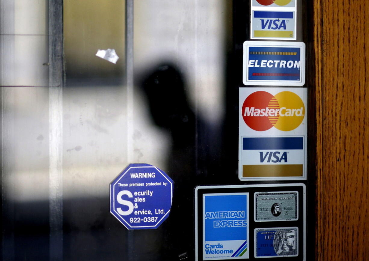 A pedestrian walks past credit card logos posted on a downtown storefront in Atlanta in 2012. After a stint of frugality, Americans have returned to their borrowing ways. But are they getting into the kinds of debt trouble that lead to recessions? In 2017, U.S. consumers now owe roughly $12.73 trillion to banks and other lenders for mortgages, car loans and credit card spending, according to the New York Federal Reserve. That exceeds even the total before the last financial crisis.