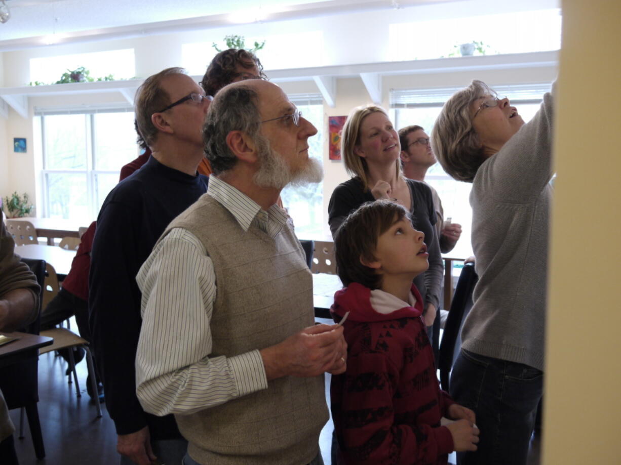 This undated photo provided by Joanna Vander Plaats shows residents of Newberry Place Cohousing Community in Grand Rapids, Mich., as they work on drafting a history of their development, built in 2007. There are 20 units that share spaces like a common house for group gatherings. Cohousing developments are designed to foster interaction between neighbors.