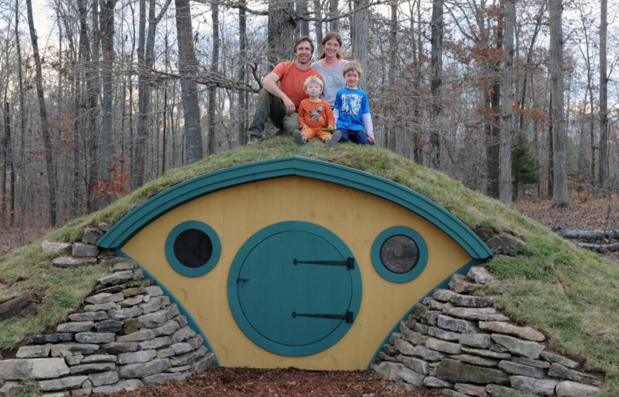 In this undated photo provided by Wooden Wonders, Rocy and Melissa Pillsbury and their children sit atop a custom Hobbit House in Santa Fe, Tenn.