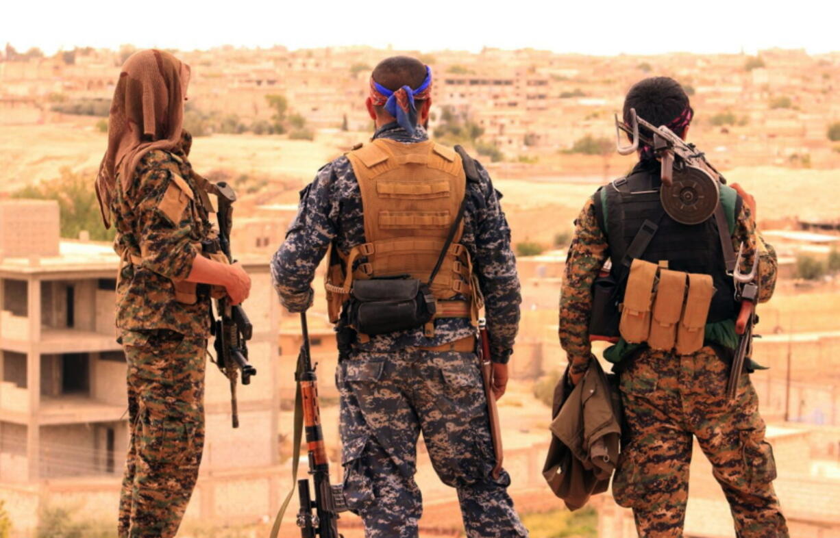 Fighters with the Syria Democratic Forces look toward the northern town of Tabqa, Syria, on April 30.