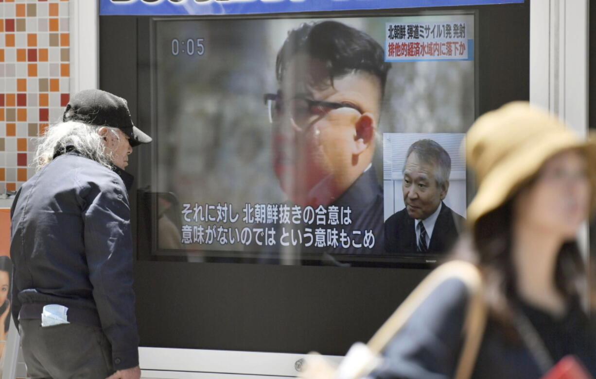 A man stands near a screen showing a file image of North Korean leader Kim Jong Un with a report of North Korea’s missile launch, in Tokyo, on Monday. North Korea fired a short-range ballistic missile that landed in Japan’s maritime economic zone Monday, officials said, in the latest in a string of test launches as the North seeks to build nuclear-tipped ICBMs that can reach the U.S. mainland.