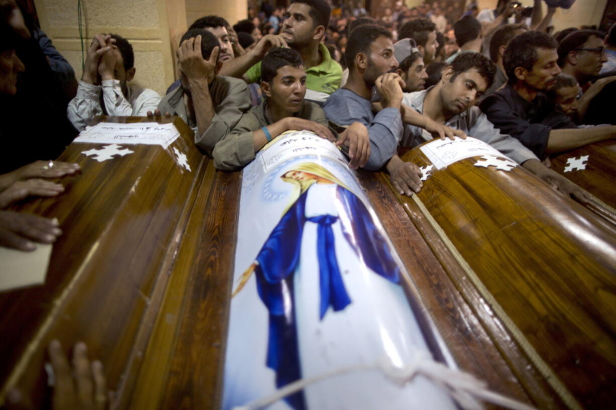 FILE - In this Friday, May 26, 2017 file photo, relatives of Coptic Christians who were killed during a bus attack, surround their coffins, during their funeral service, at Abu Garnous Cathedral in Minya, Egypt. The Libya connection in the Manchester concert bombing and FridayÇƒÙs attack on Christians in Egypt has shone a light on the threat posed by militant Islamic groups that have taken advantage of lawlessness in the troubled North African nation to put down roots, recruit fighters and export jihadists to cause death and carnage elsewhere.