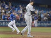 Seattle Mariners starting pitcher Christian Bergman walks back up the mound after giving up a two-run home run to Toronto Blue Jays' Jose Bautista, rounding the bases at left, during the third inning of a baseball game in Toronto on Friday May 12, 2017.