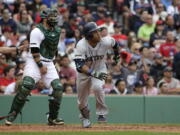 Seattle Mariners' Robinson Cano, right, watches the flight of his two-run home run as Boston Red Sox's Sandy Leon, left, looks on in the ninth inning of a baseball game, Sunday, May 28, 2017, in Boston. The Mariners shut out the Red Sox 5-0.