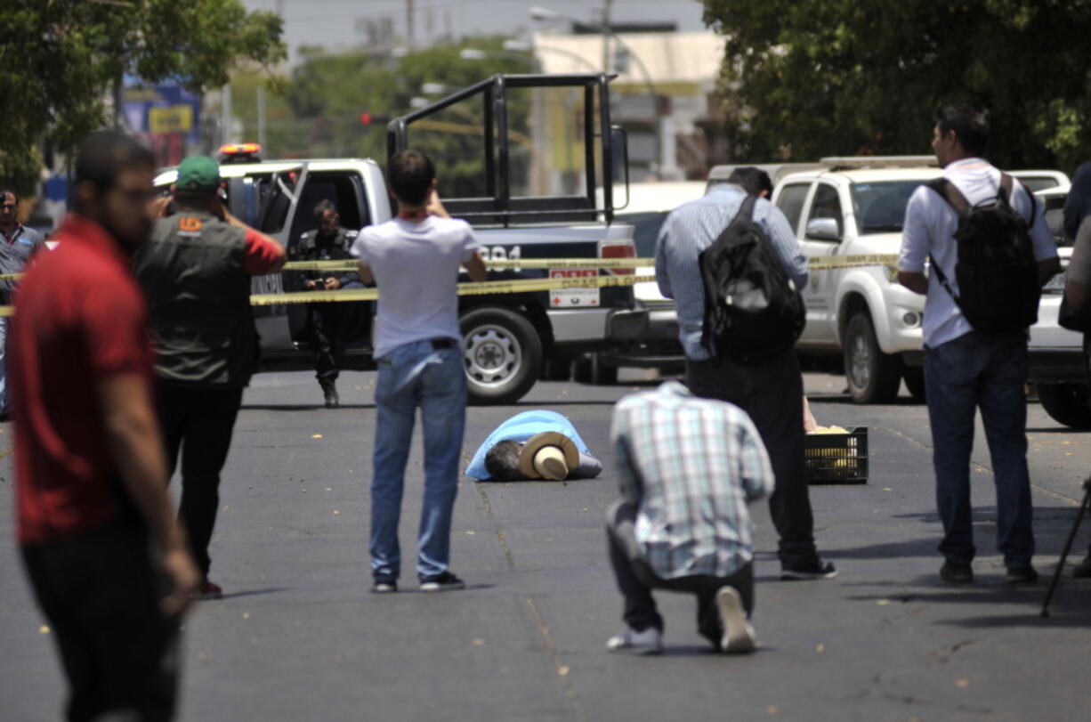 People take photos of the body of slain journalist Javier Valdez, in Culiacan, Mexico. Valdez’s killing spurred an outcry unseen previously during the frequent murders of Mexican journalists. It has drawn together competing media outlets, as well as foreign governments, the international press and human rights organizations in a call for justice that President Enrique Pena Nieto has promised to address.