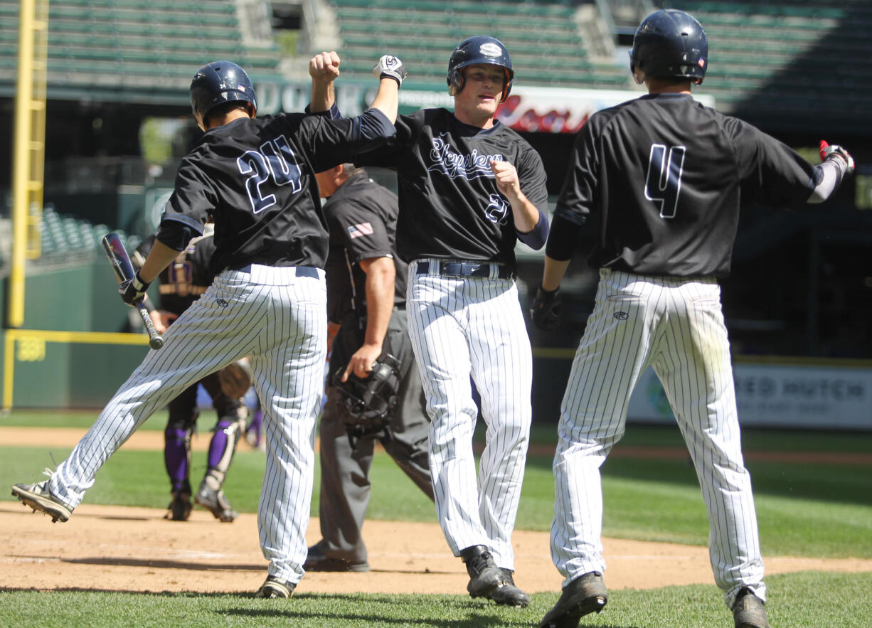 Skyview baserunner Brody Barnum (21) celebrates with teammates Liam Kerr (24) and Tanner Jacques (4) as he crosses home plate to score a run against the Puyallup Vikings in a WIAA 4A State Semifinals baseball game at Safeco Field on May 26, 2017 in Seattle. Puyallup beat Skyview 5-4 to advance to Saturday's State Championship game.