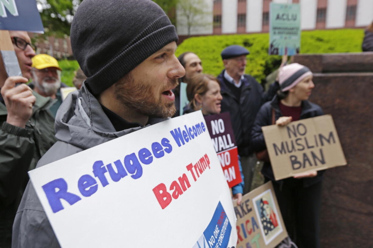 Miles Treakle, left, of Seattle, holds a sign that reads “Refugees Welcome Ban Trump,” as he protests against President Donald Trump’s revised travel ban on Monday outside a federal courthouse in Seattle. A three-judge panel of the 9th U.S. Circuit Court of Appeals heard arguments Monday in Seattle over Hawaii’s lawsuit challenging the travel ban, which would suspend the nation’s refugee program and temporarily bar new visas for citizens of Iran, Libya, Somalia, Sudan, Syria and Yemen. (AP Photo/Ted S.