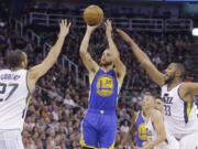 Golden State Warriors guard Stephen Curry (30) shoots as Utah Jazz&#039;s Rudy Gobert (27) and Boris Diaw (33) defend in the first half during Game 4 of the NBA basketball second-round playoff series, Monday, May 8, 2017, in Salt Lake City.