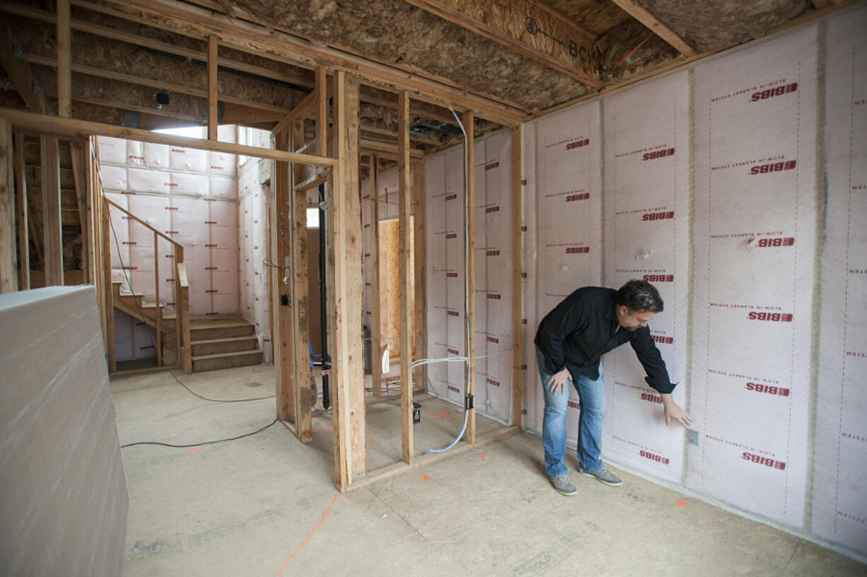 Troy Johns, owner of Urban NW Homes, looks over walls equipped with advance sealing techniques in a three-bedroom home under construction. Johns said he’s finding more homeowners demanding energy-efficient homes.