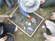 Children take turns digging and sifting dirt in a mock archaeology dig at Fort Vancouver.