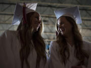 Breezy Hockett of Toutle, left, and Hailey Kimbrough of Longview chat as they wait for the Clark College commencement ceremony to begin Thursday evening at Sunlight Supply Amphitheater in Ridgefield.