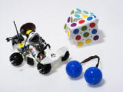 It’s smart to pack a few low-tech toys — such as (clockwise from left) Playmobil’s Space Exploration set, Cube-tastic or Thumb Chucks — for times when you can’t use electronics.